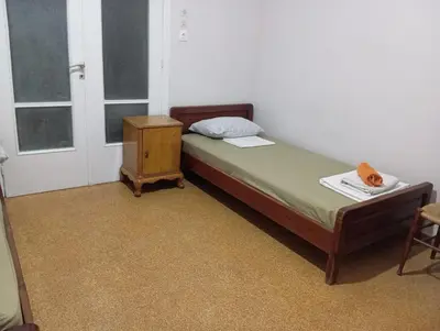 a small bedroom with a bed and a night stand at Room for 2 persons next to metro in Athens