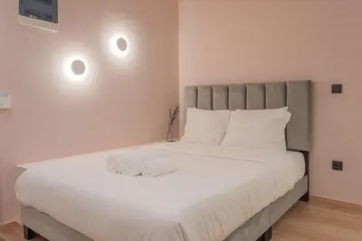 a bedroom with a large white bed with two towels on it at Acropolis View Dream Penthouse in Athens