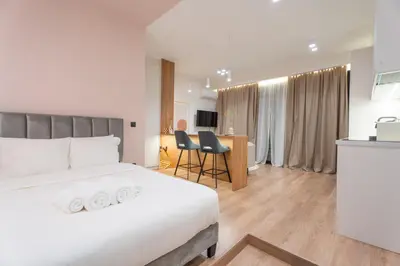 a hotel room with a bed and a desk with chairs at Acropolis View Dream Penthouse in Athens