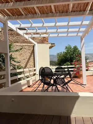 a patio with a table and chairs on a deck at Acropolis View-Themelio Suite - Acropolis Area in Athens