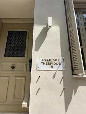 a sign on the side of a house with a door at Acropolis View-Themelio Suite - Acropolis Area in Athens