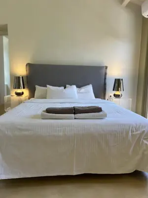 a large white bed with two towels on it at Acropolis View-Themelio Suite - Acropolis Area in Athens