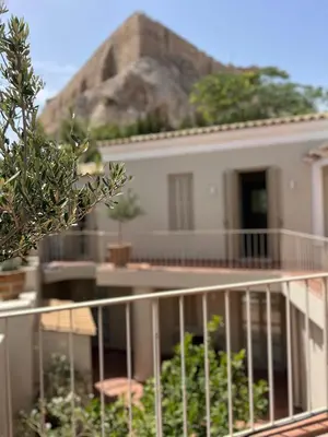 a white house with a mountain in the background at Acropolis View-Themelio Suite - Acropolis Area in Athens