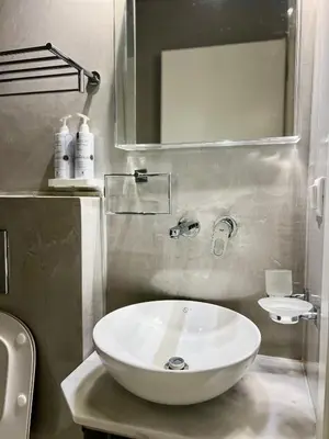 a bathroom with a white sink and a mirror at Two-bedrooms Suite - Themelio Suites - Acropolis Area in Athens