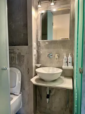a bathroom with a sink and a toilet and a mirror at Two-bedrooms Suite - Themelio Suites - Acropolis Area in Athens