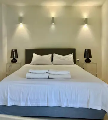 a bedroom with a white bed with two towels on it at Two-bedrooms Suite - Themelio Suites - Acropolis Area in Athens