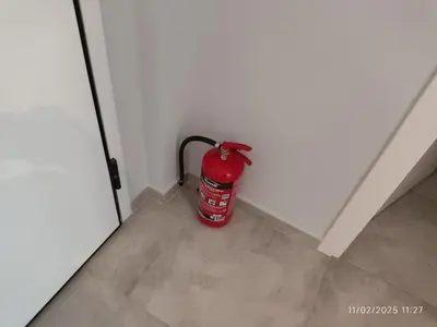 a fire extinguisher sitting in the corner of a room at Modern apt in downtown by MK in Athens