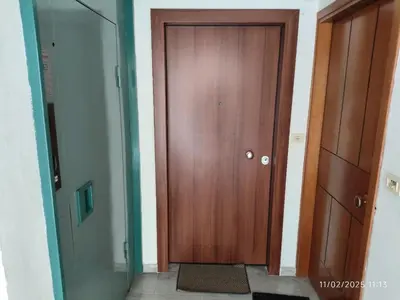 a hallway with a wooden door in a room at Modern apt in downtown by MK in Athens