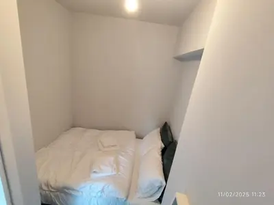 a small white room with a bed in it at Modern apt in downtown by MK in Athens