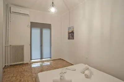 a white room with a bed and a window at Just Home Cozy Fully Renovated Apt in Athens