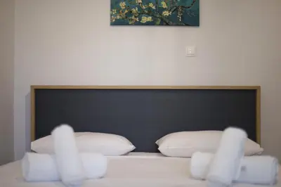 a bed with a black head board with white pillows at Just Home Cozy Fully Renovated Apt in Athens