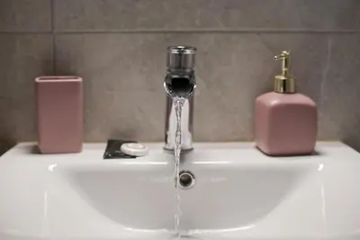 a sink with a wine glass and a soap dispenser at Just Home Cozy Fully Renovated Apt in Athens
