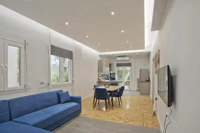 a living room with a blue couch and a table at Just Home Cozy Fully Renovated Apt in Athens