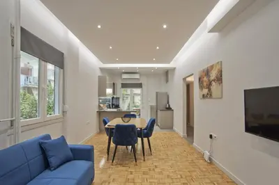 a living room with a blue couch and a table at Just Home Cozy Fully Renovated Apt in Athens