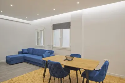 a living room with a blue couch and a wooden table at Just Home Cozy Fully Renovated Apt in Athens