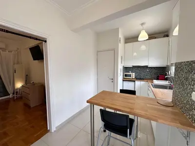 a kitchen with white cabinets and a wooden counter top at Acropolis Loft 26 in Athens