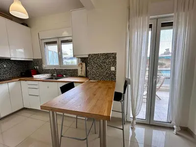 a kitchen with a wooden table and a large window at Acropolis Loft 26 in Athens
