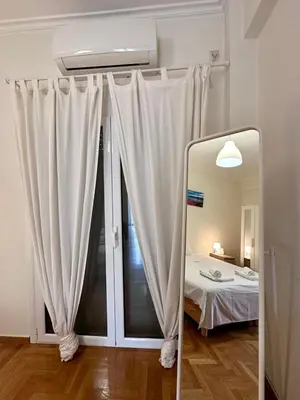 a mirror in a room with a bed and a window at Acropolis Loft 26 in Athens