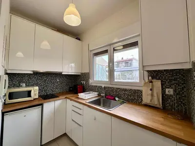a kitchen with white cabinets and a sink and a window at Acropolis Loft 26 in Athens