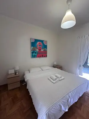 a bedroom with a white bed with two towels on it at Acropolis Loft 26 in Athens