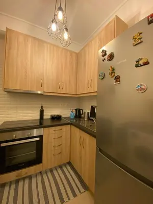 a kitchen with wooden cabinets and a stainless steel refrigerator at In between Syntagma & Plaka in Athens