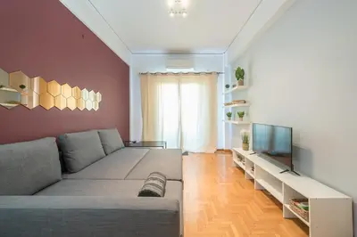 a living room with a couch and a flat screen tv at Thissio Central - Pedestrian path in Athens