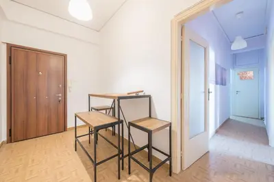 a room with two chairs and a table and a door at Thissio Central - Pedestrian path in Athens