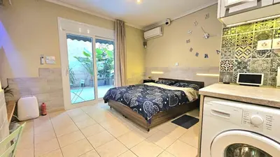 a bedroom with a bed and a washing machine at Έξυπνο όμορφο στούντιο διαμέρισμα στην Αθήνα με αυλή in Athens