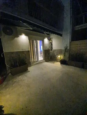 an empty room with plants and a window at night at Έξυπνο όμορφο στούντιο διαμέρισμα στην Αθήνα με αυλή in Athens