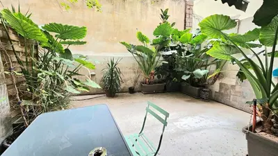 a patio with a table and plants in a courtyard at Έξυπνο όμορφο στούντιο διαμέρισμα στην Αθήνα με αυλή in Athens