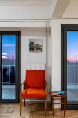 an orange chair in a room with windows at Athens Panorama Penthouse by Acropolis in Athens