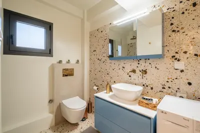 a bathroom with a sink and a toilet and a mirror at Athens Panorama Penthouse by Acropolis in Athens