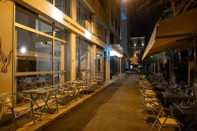 a row of tables and chairs outside of a building at night at Athens Panorama Penthouse by Acropolis in Athens