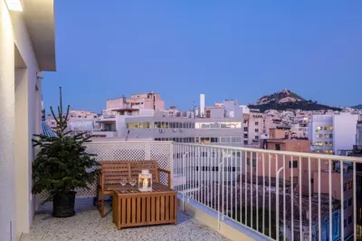 a balcony with a table and a view of a city at Athens Panorama Penthouse by Acropolis in Athens