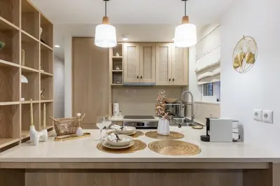 a kitchen with a table with plates and glasses on it at Vouliagmeni Square Resort in Athens