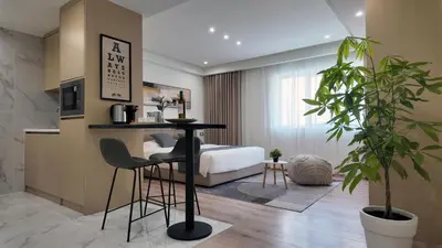 a bedroom with a bed and a table and chairs at CC LUX Suites in Piraeus Port in Piraeus