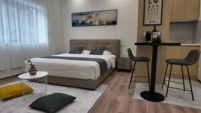 a bedroom with a bed and two chairs and a table at CC LUX Suites in Piraeus Port in Piraeus