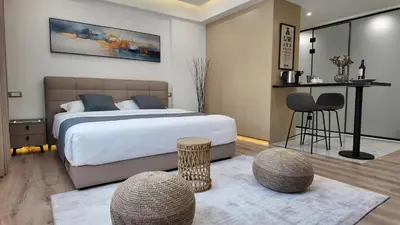 a bedroom with a bed and two chairs and a table at CC LUX Suites in Piraeus Port in Piraeus