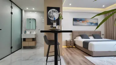 a bedroom with a bed and a bathroom with a sink at CC LUX Suites in Piraeus Port in Piraeus