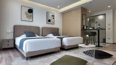a bedroom with two beds and a table at CC LUX Suites in Piraeus Port in Piraeus