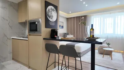 a kitchen with a bar with chairs and a bottle of wine at CC LUX Suites in Piraeus Port in Piraeus