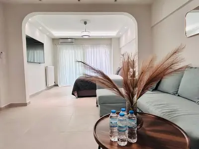 a living room with a couch and water bottles on a table at J seaside cozy APT in Athens