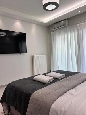 a bedroom with a large bed with two pillows on it at J seaside cozy APT in Athens