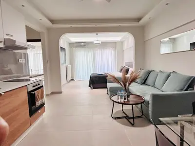 a living room with a couch and a table at J seaside cozy APT in Athens