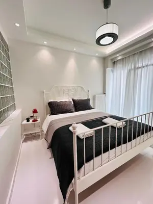 a bedroom with a large bed in a white room at J seaside cozy APT in Athens