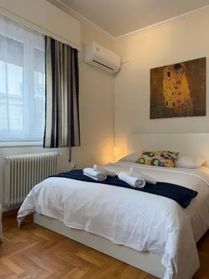a bedroom with a white bed and a window at Near Acropolis Sunny Apartment! in Athens