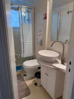 a white bathroom with a sink and a toilet at Near Acropolis Sunny Apartment! in Athens