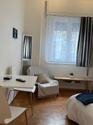 a room with a bed and a table and a chair at Near Acropolis Sunny Apartment! in Athens