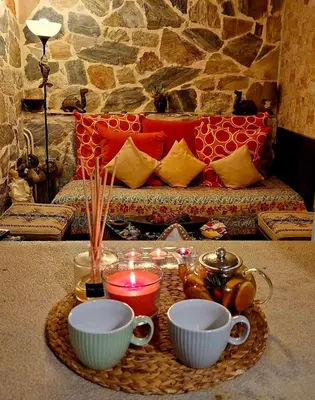 a tray with a candle and cups and a couch at STONE of KAMARIZA in Áyios Konstandínos