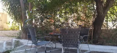 two chairs and a table under a tree at STONE of KAMARIZA in Áyios Konstandínos